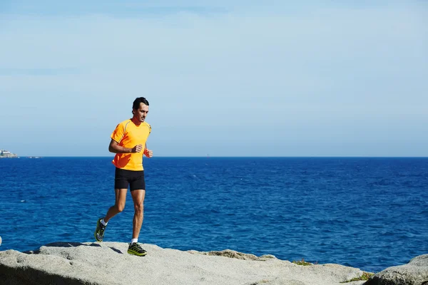 Średnim wieku człowiek w treningu biegania na świeżym powietrzu nad morzem — Zdjęcie stockowe
