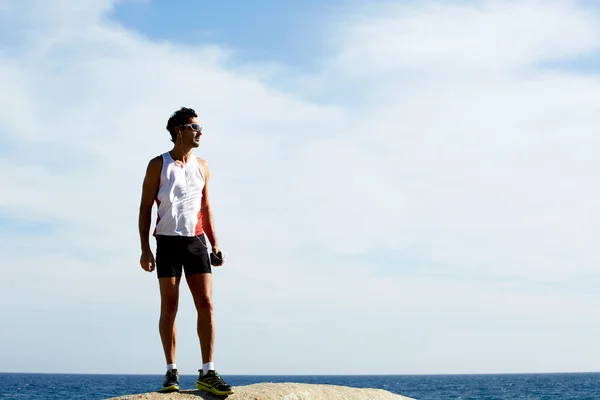 Измученный бегун после тренировки отдыхает на берегу моря — стоковое фото