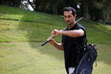 Oyuncu zaman güzel golf sahası üzerinde yürüyüş sırasında kontrol