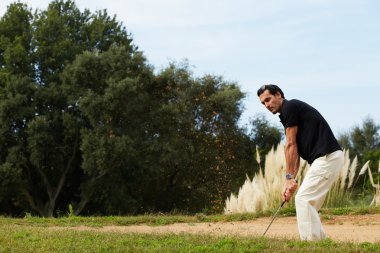 Yakışıklı adam golf kum tuzağına Golf topu isabet