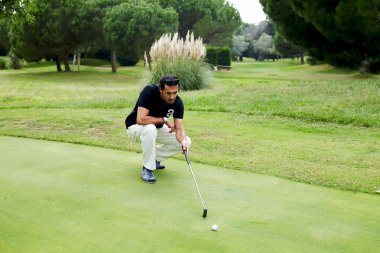 Golf topu vurmak için hazırlık kursunda ayakta golfçü