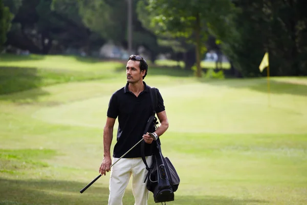 Jugador de golf llevando su bolso y caminando en el campo de golf — Foto de Stock