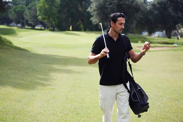 Profesyonel golf oyuncu kursunda yürüme topu bakıyor