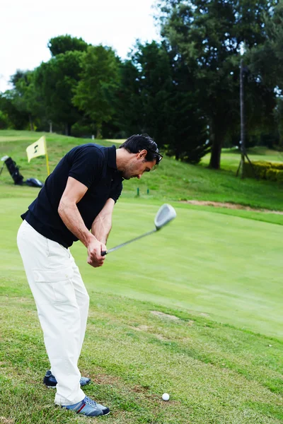 Atractivo golfista golpeando con el club de pie en el campo — Foto de Stock