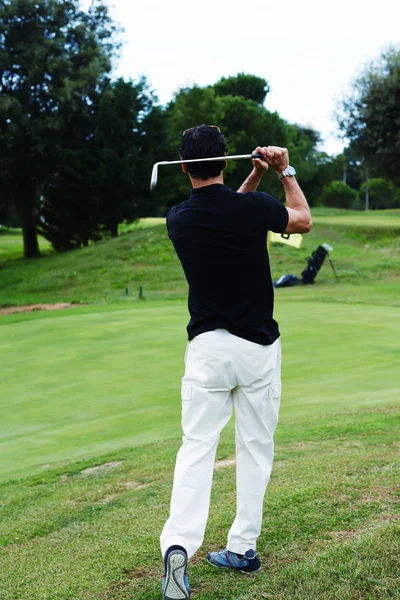 Сильный выстрел в гольф красивого игрока, стоящего на поле для гольфа — стоковое фото