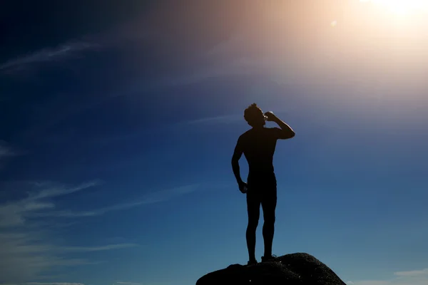 Silueta de corredor disfrutando de un día soleado bebiendo agua —  Fotos de Stock