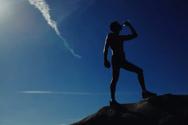 Athlète rafraîchissant avec une bouteille d'eau après l'entraînement en course — Photo