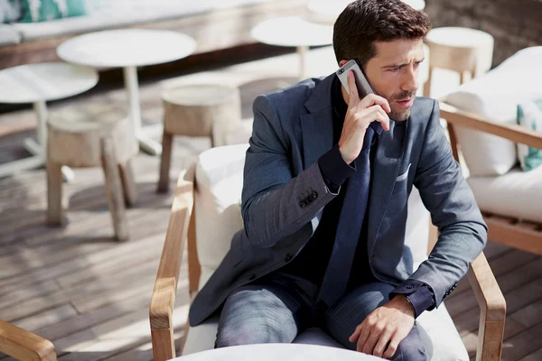 Adam telefon cep telefonuyla konuşurken gri takım elbise giymiş — Stok fotoğraf