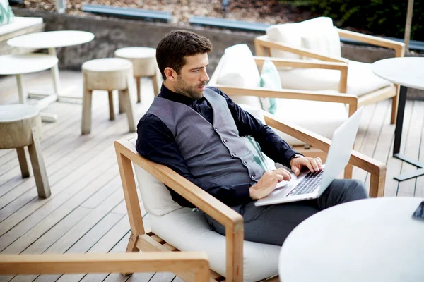 Schöner Hipster-Mann, der mit seinem Laptop im schönen Restaurant arbeitet, überall arbeitet — Stockfoto