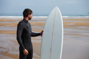 Çekici genç sörfçü sörf gitmek için harika bir yer bulmak için denize bakarak sahilde duran dalgalar, okyanus seyir sörf tahtası ile profesyonel sörfçü surfboard tutarken görüntü filtre