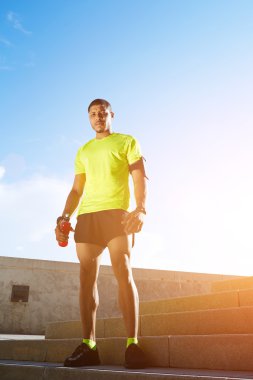 Karanlık atletik runner kas güçlü vücut parlak floresan spor giyim, koşu, güzel uygun adam spor sonra fitness kavramı dinlenme derili.