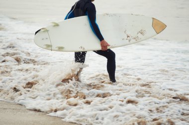 Sörf tahtasına onun surfboard ile arka plan, okyanusta taşıyan yakışıklı sörfçü yürüyüşler Sahilde yürüyüş tutarak çekici profesyonel sörfçü görüntü filtre