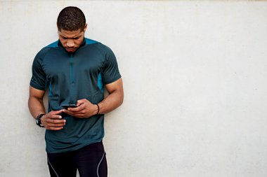 Uygun adam açık havada hareket eden smartphone tutan egzersiz yaptıktan sonra dinlenme