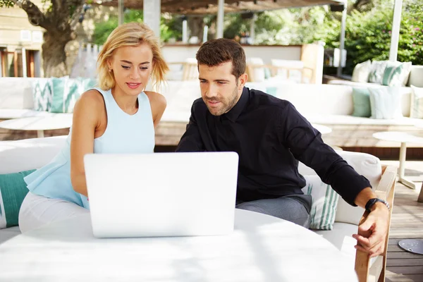 Business team of two successful people sitting outdoors in lounge terrace and planning work, businessman and businesswoman meeting in modern cafe, business partners having working with computer — Stock Photo, Image