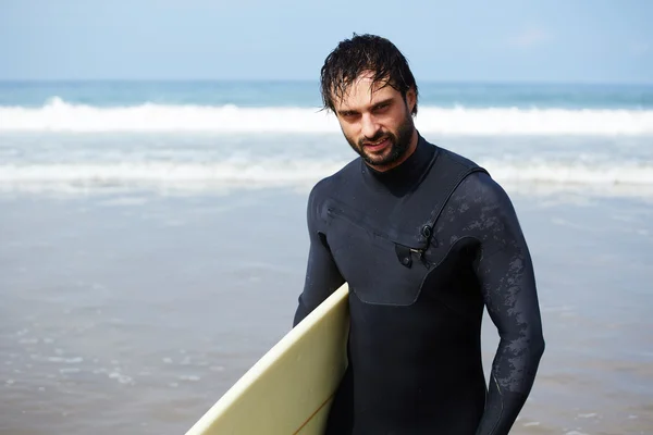 Vonzó fiatal szörfös, szörf tartja, miközben nézte óceánt, hogy megtalálja a tökéletes hely, hogy menjen a szörfözés a strandon álló hullámok, profi szörfös a surf fórumon nézte az óceánt, szűrt kép — Stock Fotó