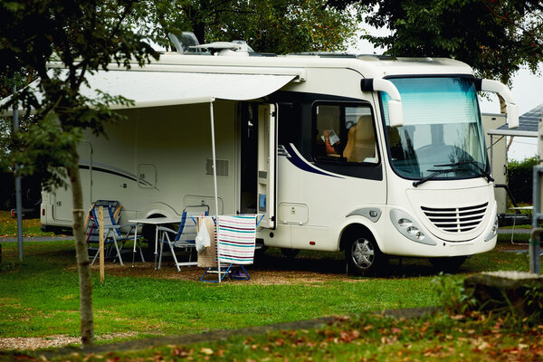 white car with a awning at a camp site