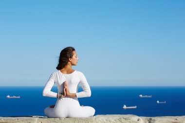 Deniz ile yüksek irtifa Yoga arka plan üzerinde savaş gemileriyle, kadın kadın güneşli akşam zevk yoga meditasyon yoga poz şaşırtıcı deniz arka plan üzerinde oturmuş, kadın yoga meditasyon dağ tepe üzerinde yapar.