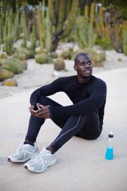 Male runner using mobile phone for browsing the internet while he have the break after sport training, sportsman using cell phone for chat