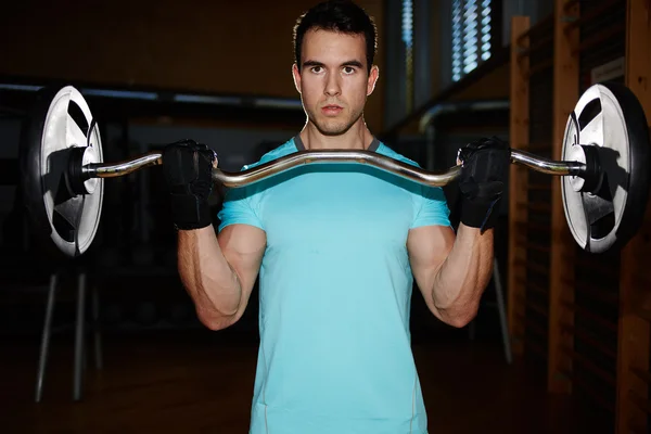 Muscular bodybuilder man doing exercises with dumbbell in gym, athletic man pumping up muscules with dumbbell, attractive young man training indoor, man doing heavy dumbbell exercise for biceps — Stock Photo, Image