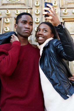 Açık havada portre çekim ile gülümseyen çiftin bir akıllı telefon, trendy çift portre fotoğrafını, arkadaşlarım ile dijital fotoğraf makinesi telefon kendi kendine portre yapma etrafında kandıramazsın