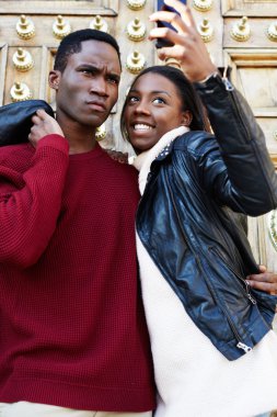 Genç ve çekici bir çiftin portresi, ellerinde akıllı bir telefonla kendilerini resmediyorlar. Birbirleriyle oynaşıyorlar. Birbirlerine aşık genç çiftler, seyahat sırasında kendi portrelerini çekiyorlar.