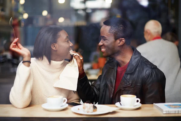 Porträt eines verliebten jungen Paares in einem Café, Freund wischt sich beim Frühstück mit Serviette den Mund ab, romantisches Paar amüsiert sich zusammen, zwei Freunde lächeln im Café — Stockfoto