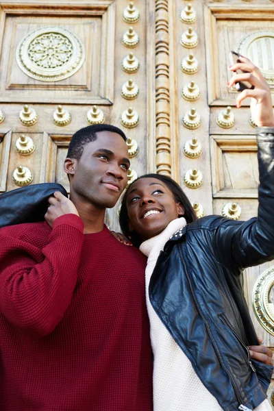 Dating couple happy in love taking self-portrait photo on beautiful antique door background, happy friends taking self portrait outdoors, tourist man and woman making self portrait with mobile phone — Stock Photo, Image