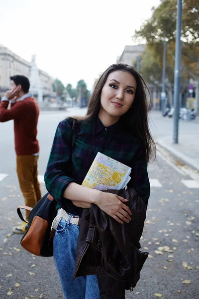 Charmoso asiático turista menina segurando mapa da cidade de pé na grande estrada bonita, elegante hipster menina de pé com o mapa da cidade na bela estrada coberta com folhas de outono — Fotografia de Stock