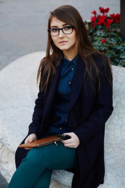 Açık havada oturan genç iş kadını