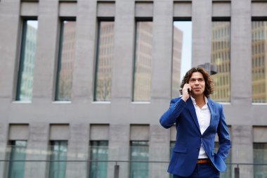 Şehirde yürüyüş ve telefonda konuşurken işadamı