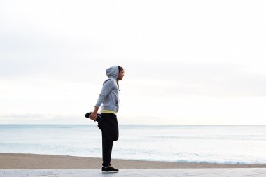 Genç adam kumsalda egzersiz