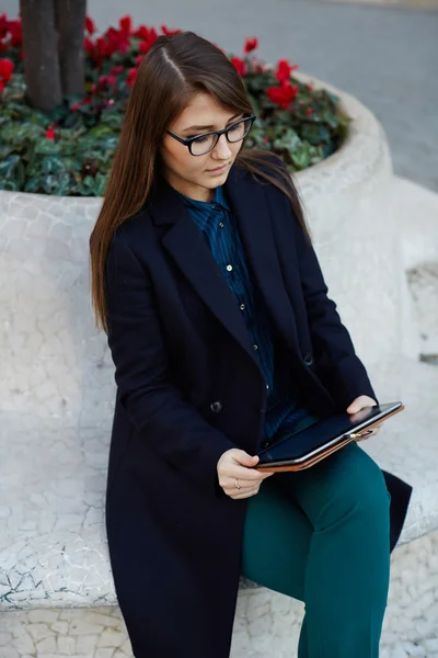 Молодая деловая женщина сидит на улице — стоковое фото