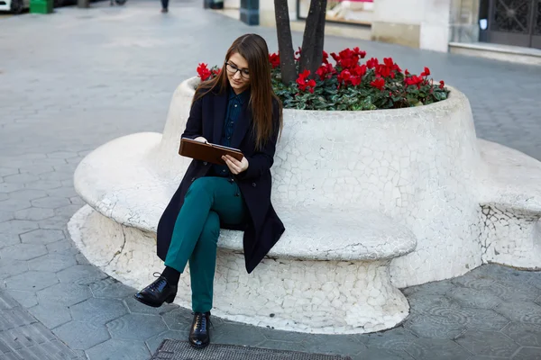 Молодая деловая женщина сидит на улице — стоковое фото