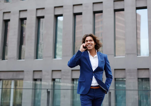 Businessman walking in the city and talking on phone — Stock Photo, Image