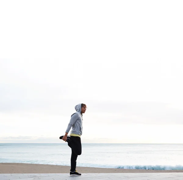 Hombre joven haciendo ejercicio en la playa — Foto de Stock