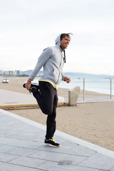 Junge Joggerin dehnt sich vor Lauf — Stockfoto