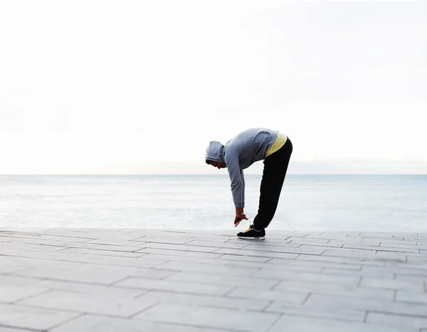 Hombre joven haciendo ejercicio en la playa — Foto de Stock