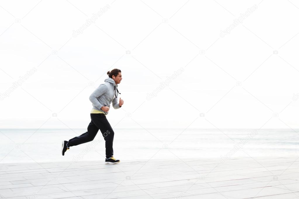 Young man running along the beach