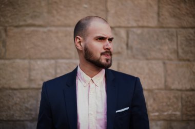 Erkek takım elbise ayakta antika duvara karşı