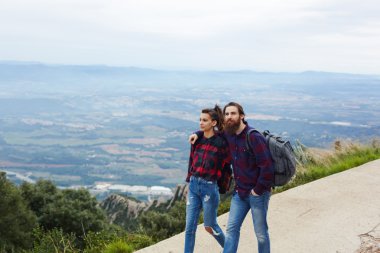 Young couple in an embrace of tourists is a walk in the mountains