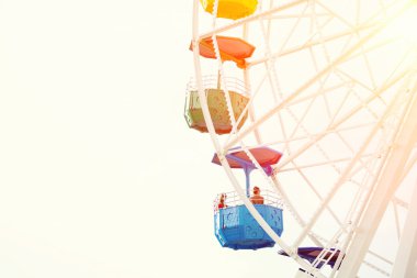 women rotating on of colorful ferris wheel