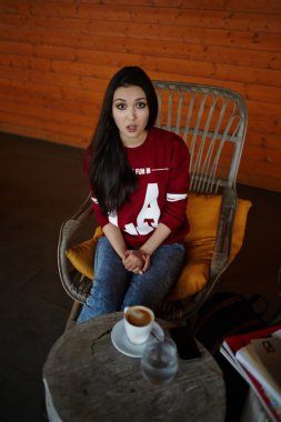 Kahve dükkanında oturan genç bir kadın.