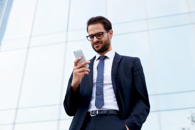 businessman smiling as he reads message