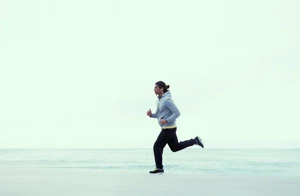 Joven corriendo por la playa — Foto de Stock