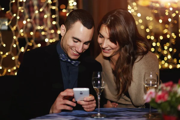 Gelukkige paar kijken naar foto's op telefoon — Stockfoto