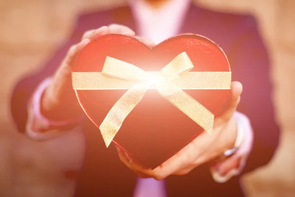 Uomo in possesso di un regalo a forma di cuore — Foto Stock