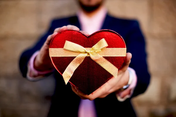 Uomo in possesso di un regalo a forma di cuore — Foto Stock