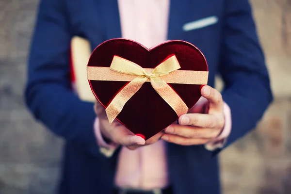 Uomo in possesso di un regalo a forma di cuore — Foto Stock