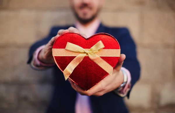 Man holding a heart shape gift — Stock Photo, Image