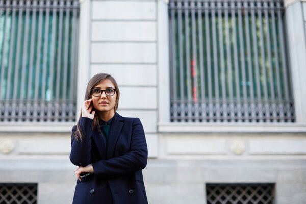 А stylish young woman posing outside in a city stree